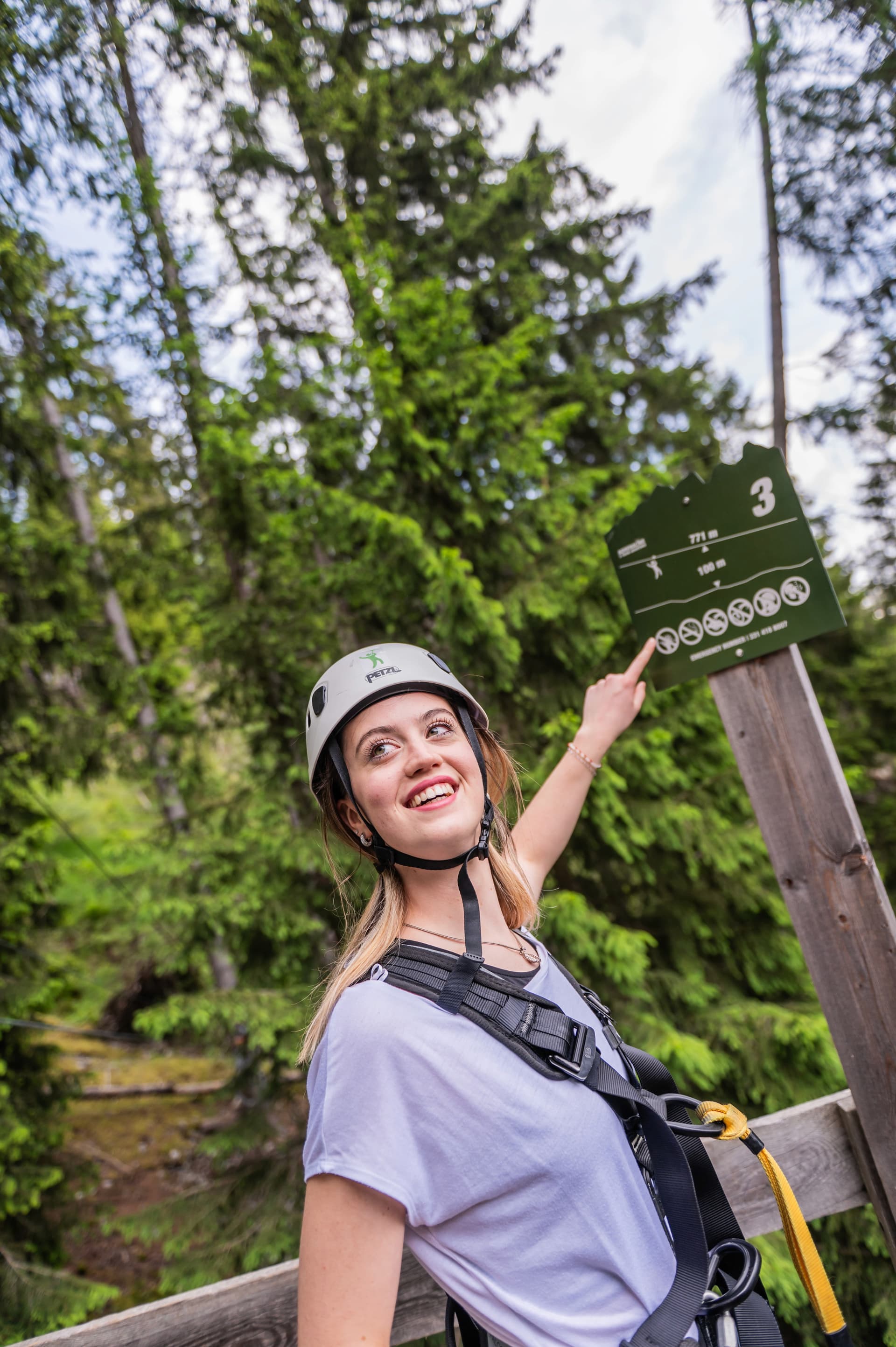 Smiling girl pointing at route 3 sign